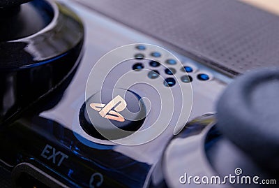Brecht, Belgium - April 13 2020: A close up portrait of the playstation home button on a PS4 wireless controller. The button has Editorial Stock Photo