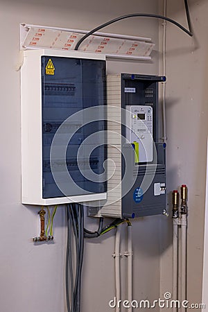 Brecht, Belgium - 26 januari 2023: Portrait of a new installed Belgian digital electricity kilowatt hour meter next to a fuse box Editorial Stock Photo