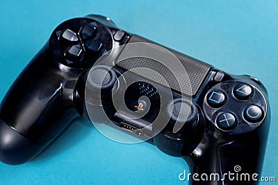 Brecht, Belgium - January 15 2020: A top down portrait of a playstation 4 console controller on a blue background Editorial Stock Photo