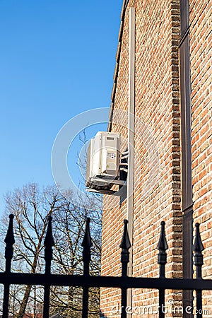 Brecht,Belgium - March 4 2022: An air conditioning unit hanging outside of a building on a brick wall, to regulate the temperature Editorial Stock Photo