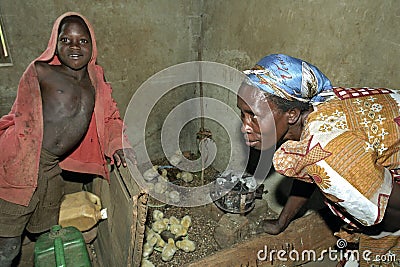 Breeding chicks by Ugandan woman with son Editorial Stock Photo
