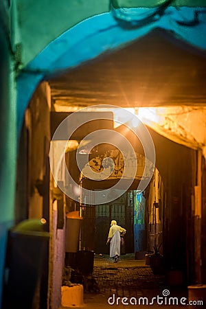 During the breeze nights, in Essaouira, mysterious men are walking alone through Medina`s narrow streets. The lights and the walls Editorial Stock Photo