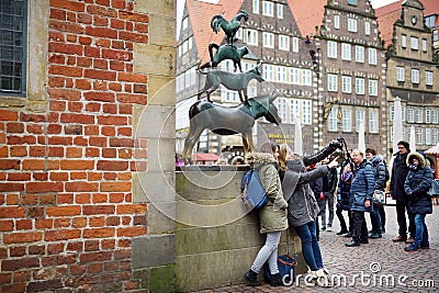 BREMEN, GERMANY - MARCH 23, 2016: Tourists taking pictures of themselves by famous statue in the center of Bremen, known as The Br Editorial Stock Photo