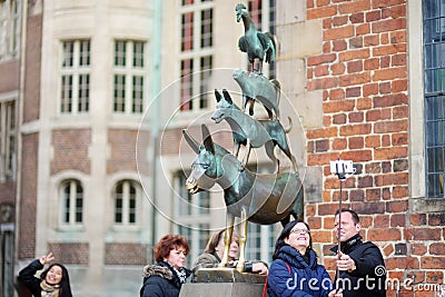 BREMEN, GERMANY - MARCH 23, 2016: Tourists taking pictures of themselves by famous statue in the center of Bremen, known as The Br Editorial Stock Photo