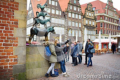 BREMEN, GERMANY - MARCH 23, 2016: Tourists taking pictures of themselves by famous statue in the center of Bremen, known as The Br Editorial Stock Photo