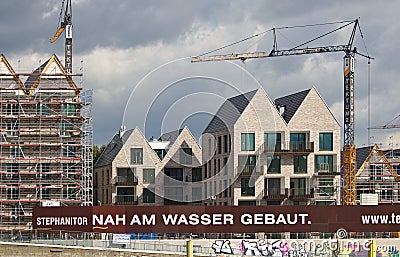Bremen, Germany - September 14th, 2017 - Riverside construction site with cranes, partly and fully completed residential buildings Editorial Stock Photo