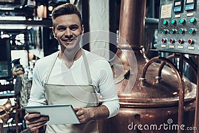Brewer Standing near Apparatus in Modern Brewery. Stock Photo