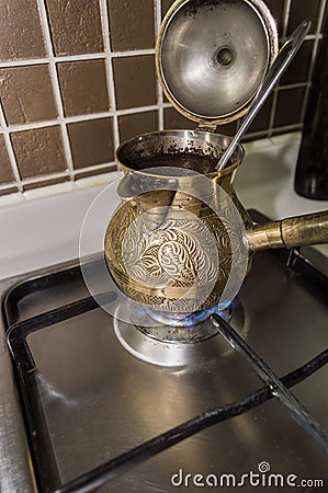 Brewing fresh coffee in bronze turkish cezva Stock Photo