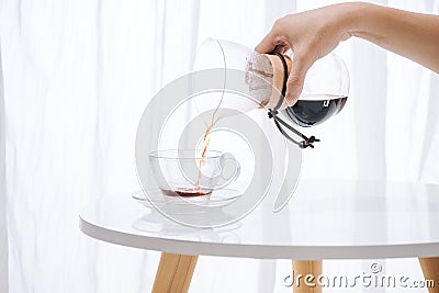 Brewing nel drip coffee. Step by step cooking instructions. Coffee is ready. Barista pouring brewed coffee in the cup Stock Photo