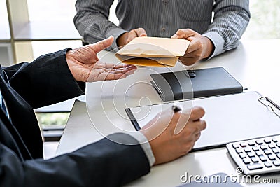 Bribery and corruption concept, bribe in the form of dollar bills, Businessman giving money in the envelope while making deal to Stock Photo