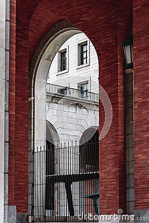 Brick arch framing stone facade building in Madrid Stock Photo