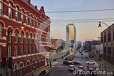 Brick building beside long, endless Chicago street with buildings at sunset with street lights, IL Editorial Stock Photo