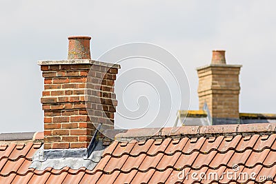 Brick chimney stack on modern contemporary house roof top Stock Photo