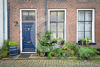 Brick Facade of Old Dutch House with flowers in pots Stock Photo