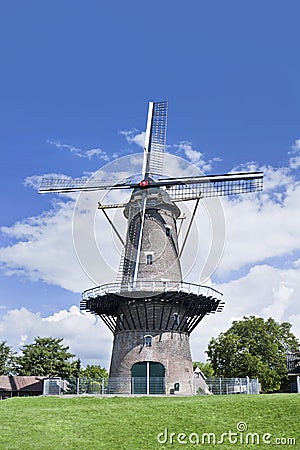 Brick floor mill in a green field with a blue sky and dramatic clouds. Stock Photo