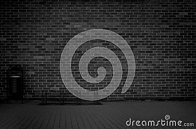 Brick grunge weathered black wall background with walkway and garbage can Stock Photo