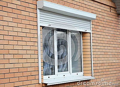 Brick house window with rolling shutter for home protection Stock Photo