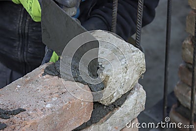 Brick mason using trowel to spread a mortar Stock Photo