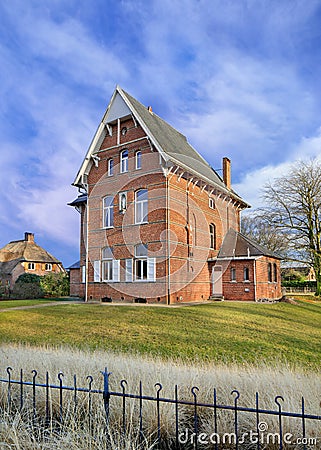 Brick parsonage against cloudy blue sky, Ravels, Flanders, Belgium Stock Photo