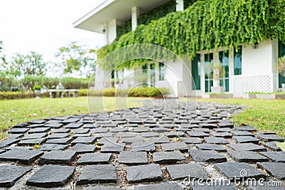 A brick paved road stretches into the garden Stock Photo