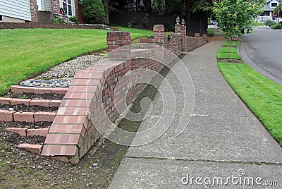 Brick retaining wall in neighborhood Stock Photo