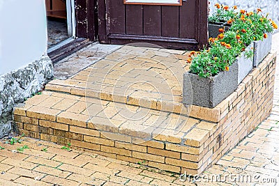 Brick threshold with a step at the open wooden entrance door. Stock Photo