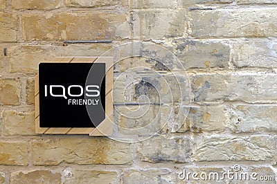 Brick wall with board IQOS friendly Editorial Stock Photo