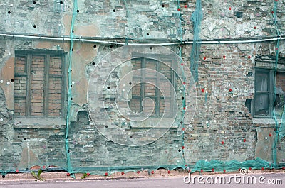 Brick wall covered green facade mesh Stock Photo