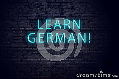 Brick wall and neon sign with inscription. Concept of learning german Stock Photo