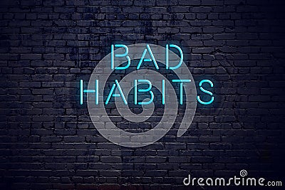 Brick wall and neon sign with text bad habits Stock Photo