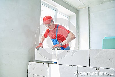 Bricklayer builder working with autoclaved aerated concrete blocks. Walling Stock Photo
