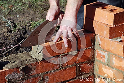 Bricklayer building wall Stock Photo