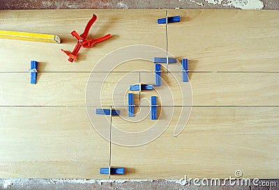 Bricklayer placing a porcelain tile floor in imitation of beechwood Stock Photo