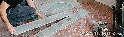 Bricklayer placing tiles to install a floor Stock Photo