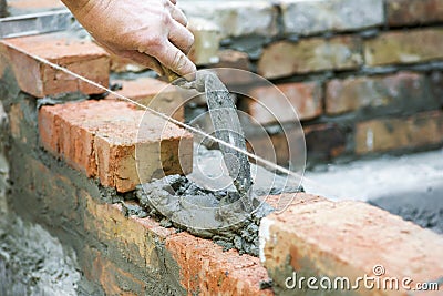 Bricklayer worker installing brick masonry on exterior wall. Professional construction worker laying bricks. Bricklayer worker Stock Photo