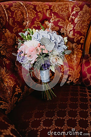 Bridal bouquet with pink roses and long ribbons on a red armchair Stock Photo