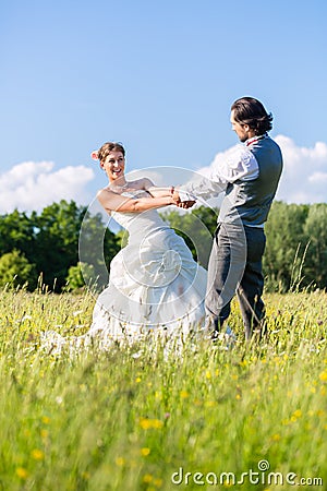 Bridal pair dancing on field celebrating Stock Photo