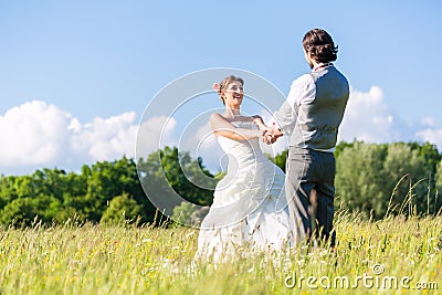 Bridal pair dancing on field celebrating Stock Photo
