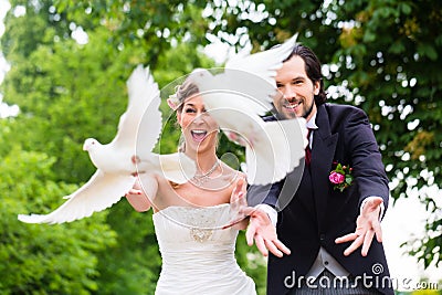 Bridal pair with flying white doves at wedding Stock Photo