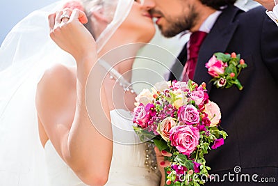Bridal pair kissing under veil at wedding Stock Photo