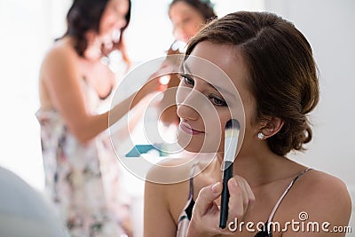 Bride applying her makeup doing her wedding preparation Stock Photo