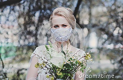 Bride with a bouquet in a protective mask Stock Photo