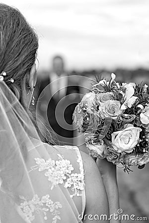 Bride with bridal bouquet in the hands of the groom expect. Stock Photo