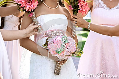 Bride and bridemaids are holding bouquets of flowers in hands on a wedding day Stock Photo
