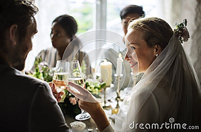 Bride and Groom Clinging Wineglasses Together at Wedding Reception Stock Photo