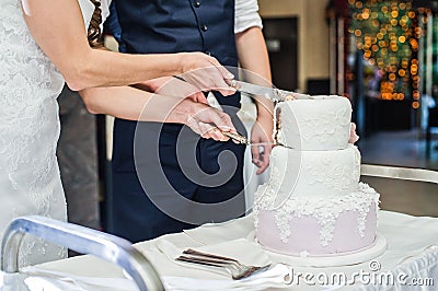 The bride and groom cut the traditional wedding cake. Stock Photo