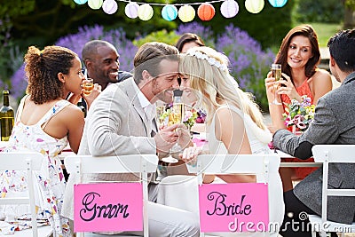 Bride And Groom Enjoying Meal At Wedding Reception Stock Photo