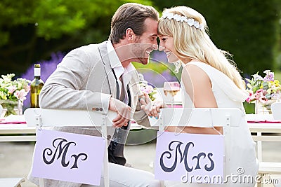 Bride And Groom Enjoying Meal At Wedding Reception Stock Photo