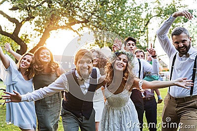 Bride, groom, guests posing for the photo at wedding reception outside in the backyard. Stock Photo