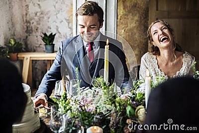 Bride and Groom Having Meal with Friends at Wedding Reception Stock Photo